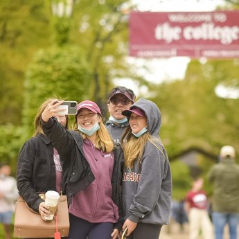 A family takes a selfie on UChicago’s Main Quandrangles