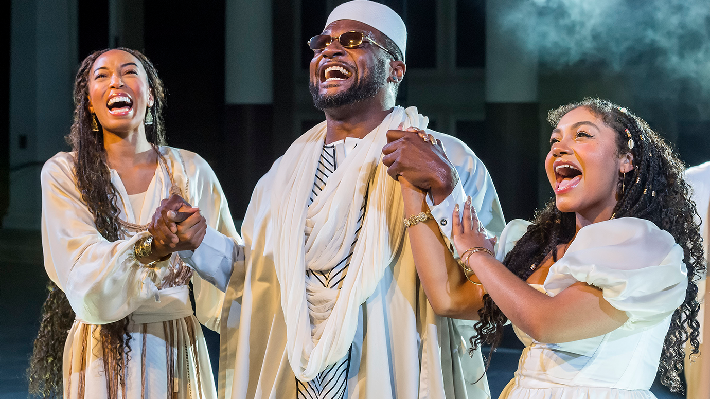 Three members of the cast of the Gospel at Colonus sing together with clasped hands. 