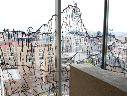 Vinal mural illustration of rocky cliffs on the window of the Logan Center. Buildings are visible through the mural.