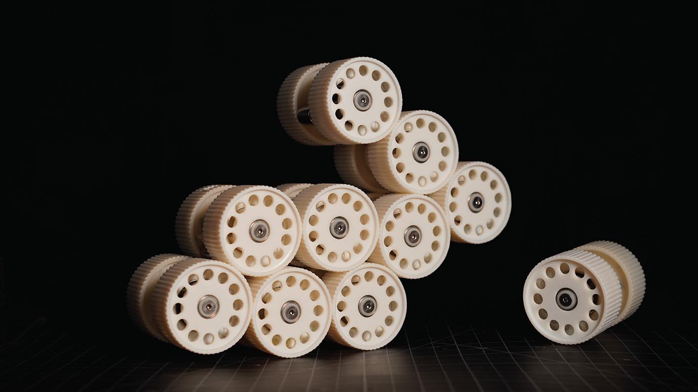 Photograph of a set of small beige cylinders stacked together on a black background
