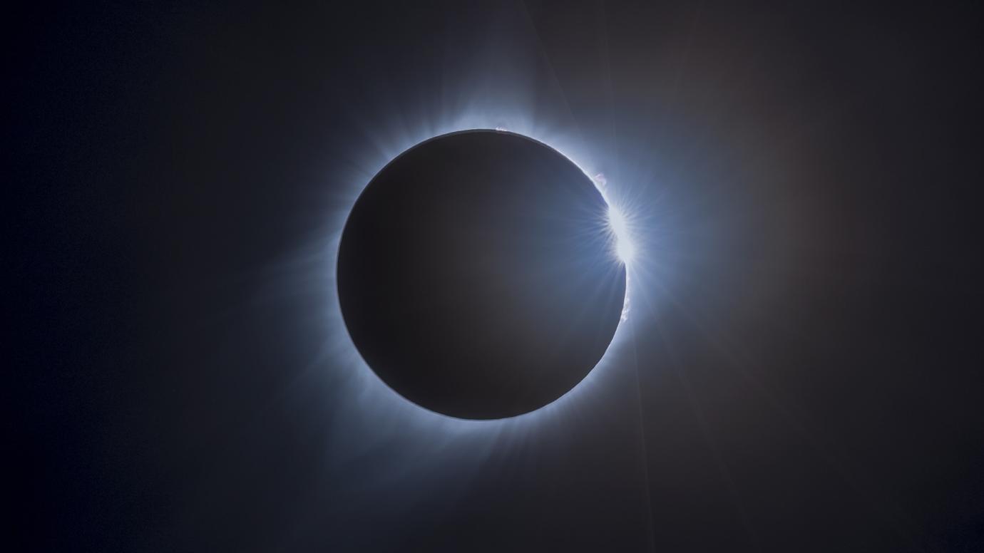 Photograph of the sky during an eclipse - the sky is completely dark and the sun is only visible as a thin ring around the moon