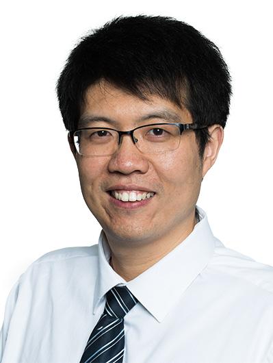 Portrait of Guangbin Dong wearing white button-down shirt and smiling at camera