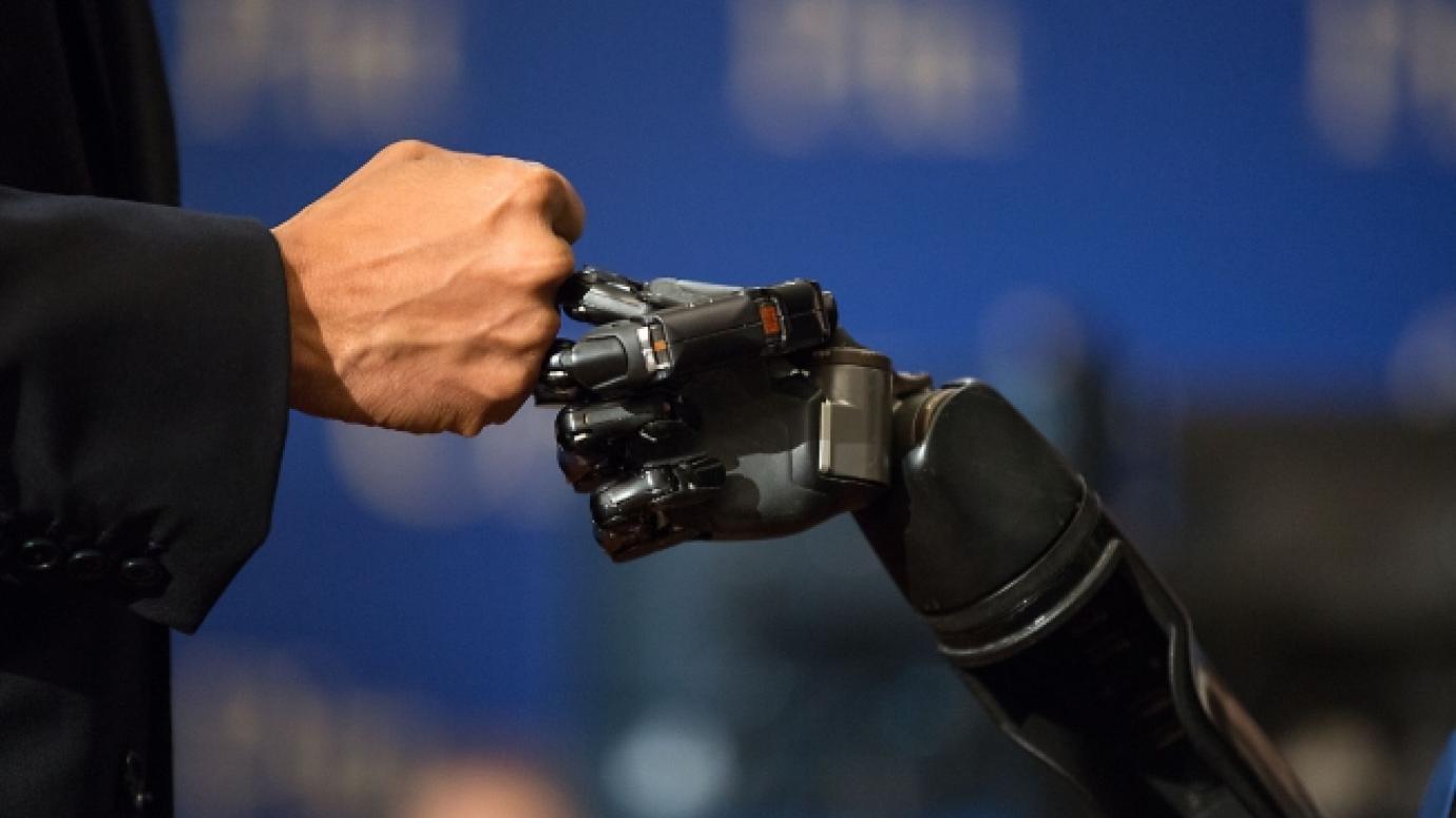 Robotic arm fist-bumping human arm