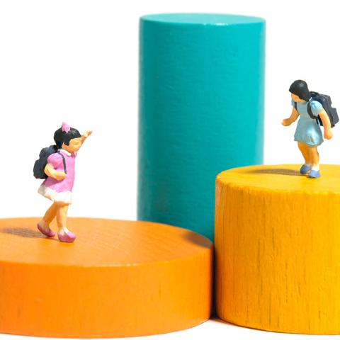 Miniature figures playing on wooden blocks
