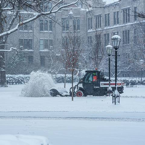 A snow plow moves through campus