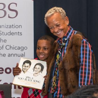 Poet Nikki Giovanni with a child following the 2020 George E. Kent Lecture