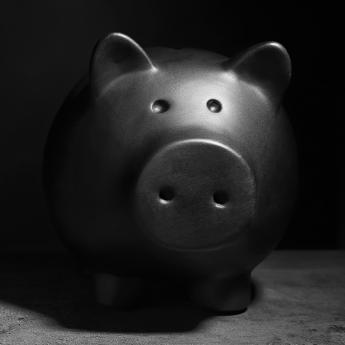Black & white photo of a piggy bank with heavy shadows