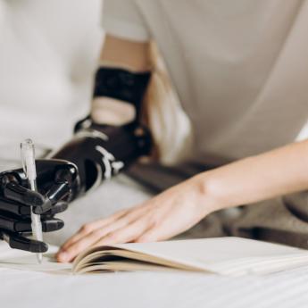Woman uses prosthetic arm to write