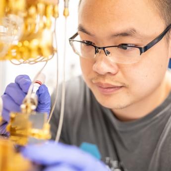 Researcher works in gloves on metallic quantum assembly