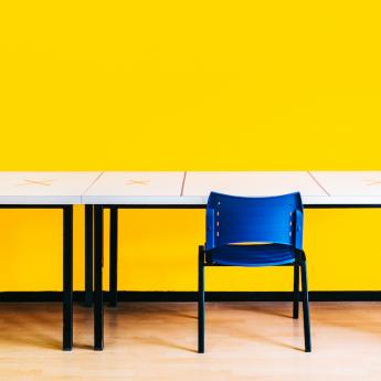 School classroom with yellow walls and blue chairs