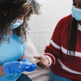 A nurse checking a patient's blood sugar