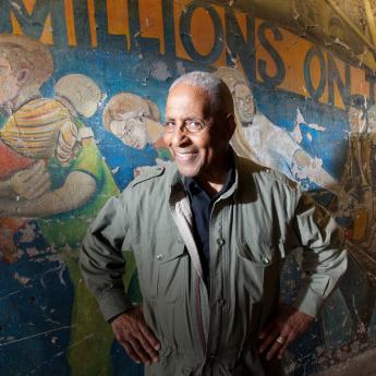 Rudy Nimocks Sr. stands in front of Caryl Yasko's "Under City Stone" mural in Hyde Park