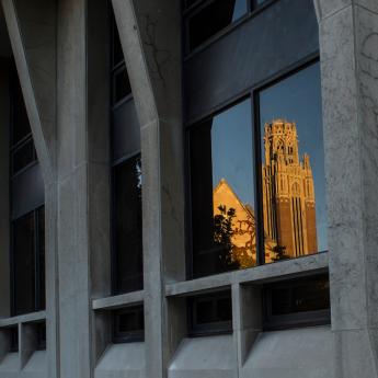 Saieh Hall reflected in the window of Pick Hall on the University of Chicago campus