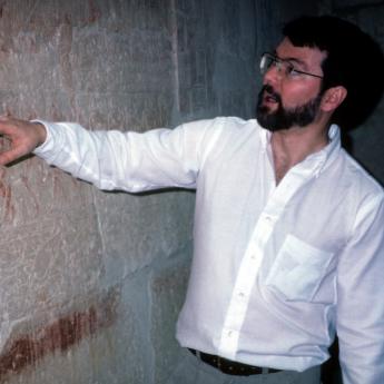 Robert Ritner gestures to markings inside a tomb