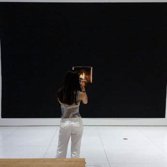 A woman takes a picture at the Smart Museum