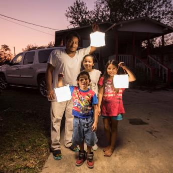 A Houston family holds up LuminAID solar-powered lanterns in the aftermath of Hurricane Harvey in 2017.