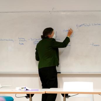 Leila Brammer writes on a whiteboard as part of a course in UChicago's Parrhesia Program