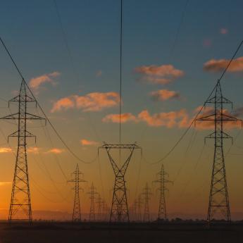 A view of electricity pylons with a sunset