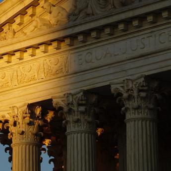 Light hits the exterior of the U.S. Supreme Court, casting a shadow on the words "equal justice" engraved above the entrance