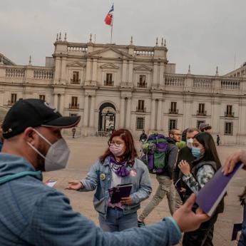 A group of individuals hand out copies of Chile's new constitution