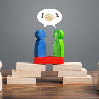 Two wooden figurines solving a problem using dialogue