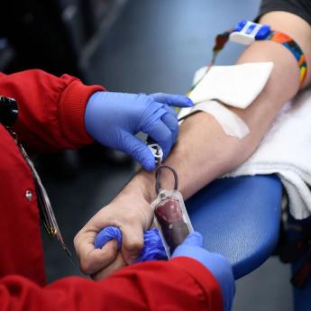 A phlebotomist takes blood from a donor
