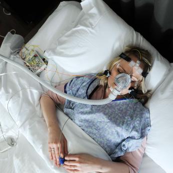 A patient lays on a bed for a sleep research study