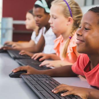 Young children use computers in a classroom