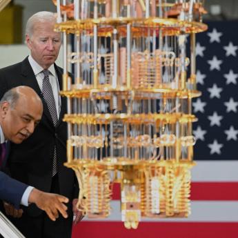 President Biden stands behind IBM CEO Arvind Krishna and examines a quantum computer