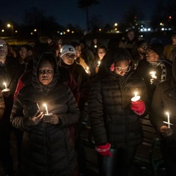 A group of people holding candles participate in a vigil for Tyre Nichols
