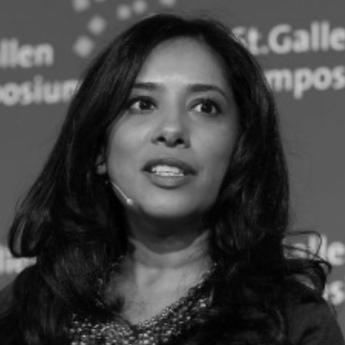 Zeenat Rahman speaks into a microphone at a symposium