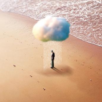 Lone figure on the beach under a raining cloud