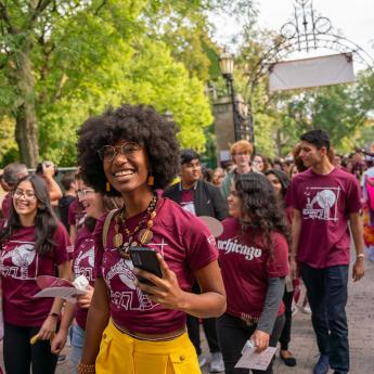 Students cheer and smile during their procession through campus for O-Week