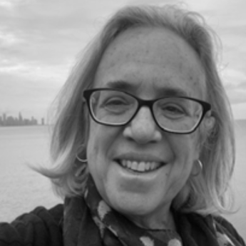 Susan Gzesh, a white woman with glasses, stands in front of Lake Michigan