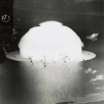A mushroom cloud billows out above the sea