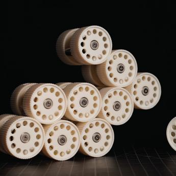 Photograph of a set of small beige cylinders stacked together on a black background