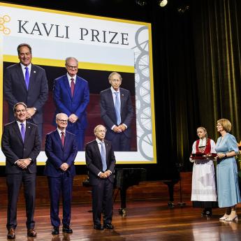 Photo of 3 scientists on a stage with The Kavli Prize backdrop behind