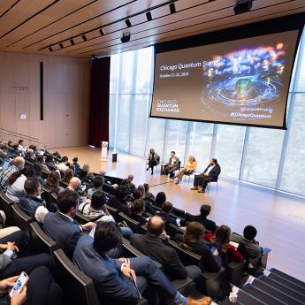 The audience watches a discussion on stage at the Rubenstein Forum during the 2024 Quantum Summit