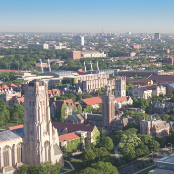 Eagle-eye view of the University of Chicago campus with downtown Chicago buildings visible in the background.