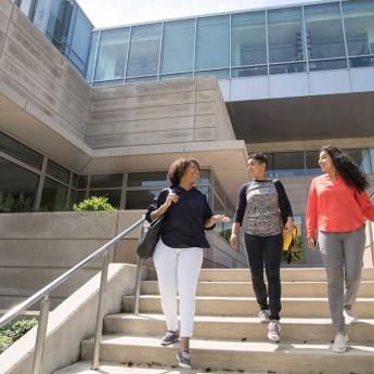 Students walk down the steps in front of the Booth School of Business