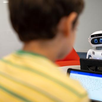 A child reads aloud to a robot
