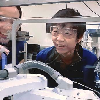 Asst. Prof. Jie Xu and Argonne staff scientist Henry Chan look at Polybot, a "self-driving lab" that uses AI to help researchers guide the materials discovery process.