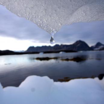 Ice melting and forming a water droplet