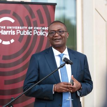 Kerwin Charles speaking in front of "Harris Public Policy" sign