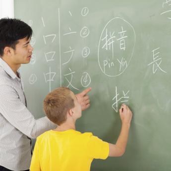 Man teaching kid to write mandarin characters