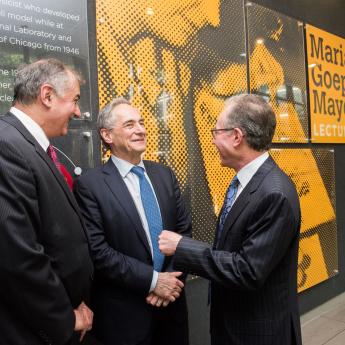 Three men talking in front of exhibit