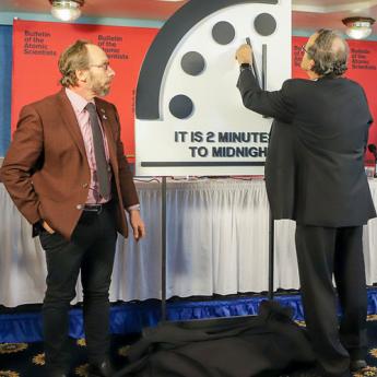 Person pointing at a fake doomsday clock
