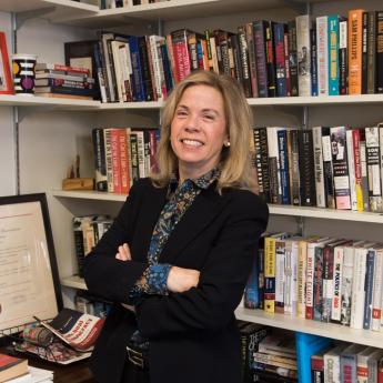 Jane Dailey posing in front of bookshelf