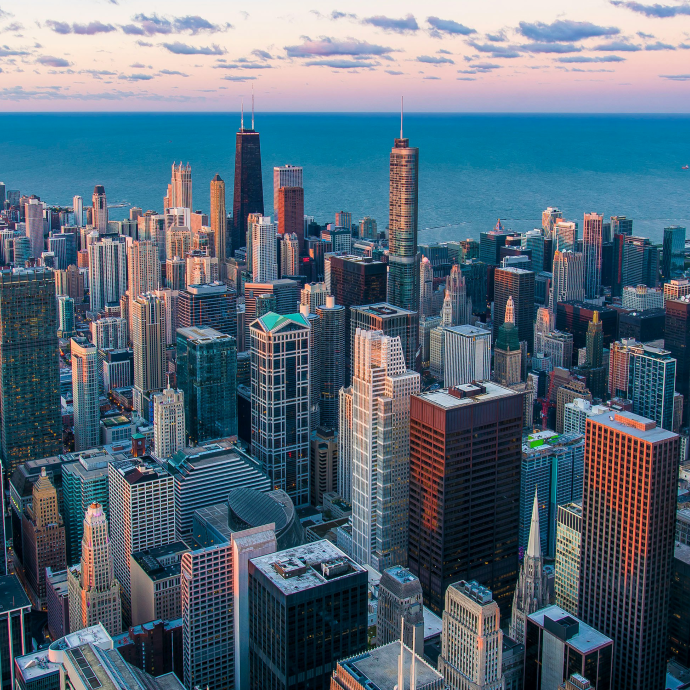 Aerial photograph of the skyscrapers of downtown Chicago with the lake visible behind, at sunset