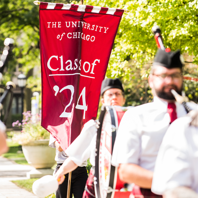 Procession of bagpipe players and drum. A banner reading "Class of '24
